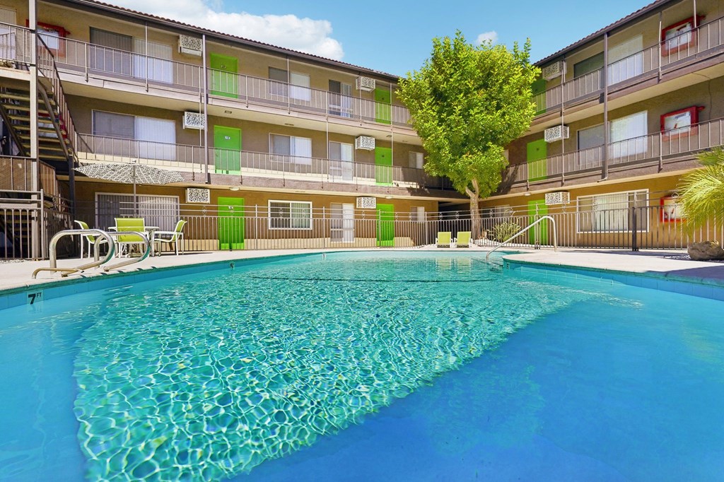 a resort style pool is in front of an apartment building