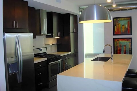 A modern kitchen with a refrigerator, stove, and sink.