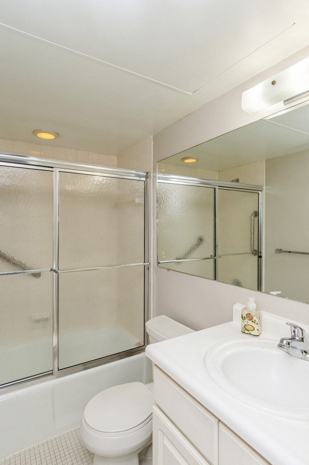 A clean bathroom with window sliding doors, a toilet and white sink