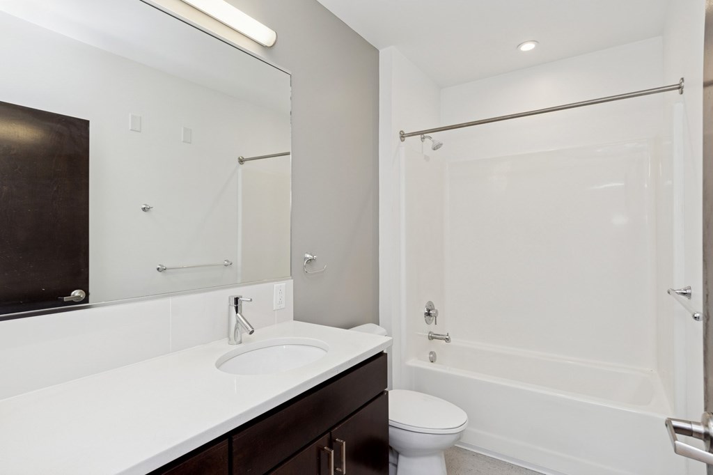 A white sink in a bathroom with a toilet and a shower.