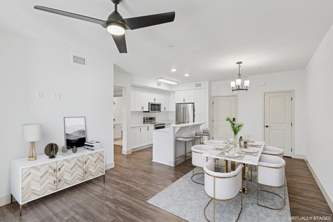 A modern dining room with a white table and chairs.