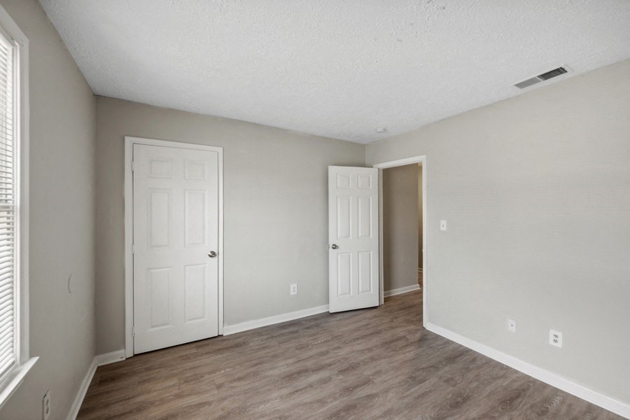 a bedroom with hardwood floors and grey walls at Fort Collier Terrace, Virginia