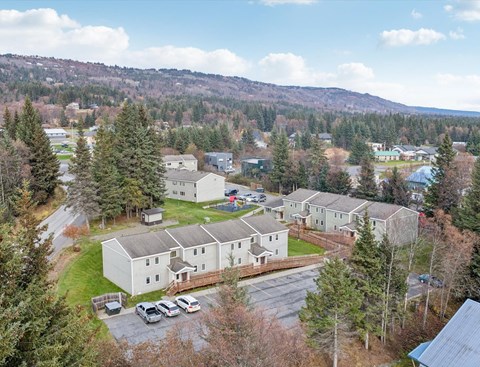 A large white building surrounded by trees and a parking lot.