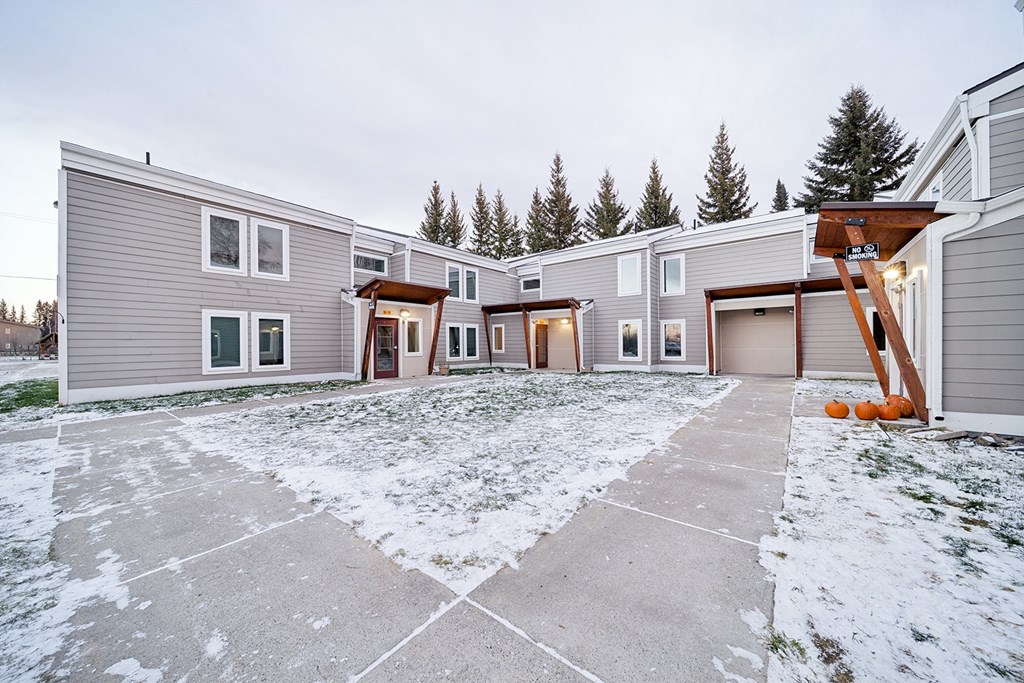 A row of houses with a snowy front yard.