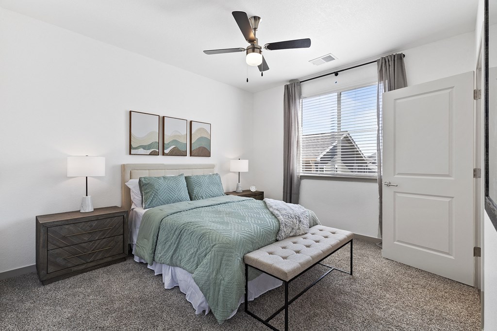 a bedroom with a bed and a ceiling fan