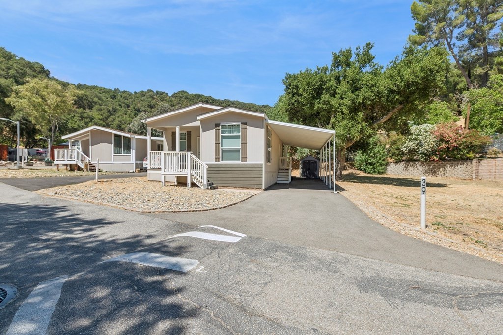 A house with a driveway and a tree in front of it.