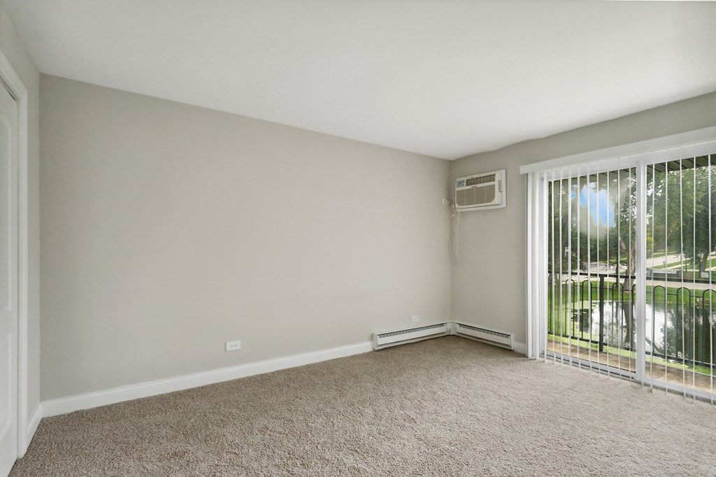 a bedroom with a sliding glass door and carpet at The Hinsdale, Hinsdale, 60521