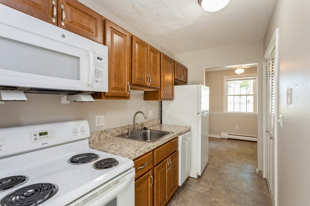 Kitchen view with white kitchen appliances and sink
