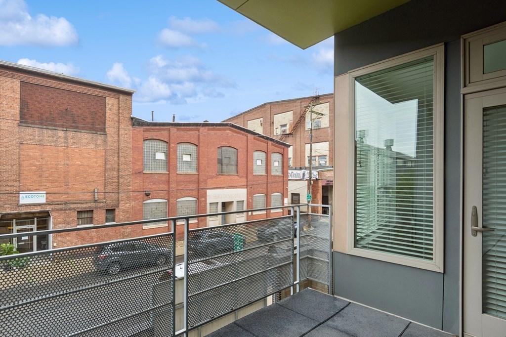 A balcony with a metal railing and a glass door.