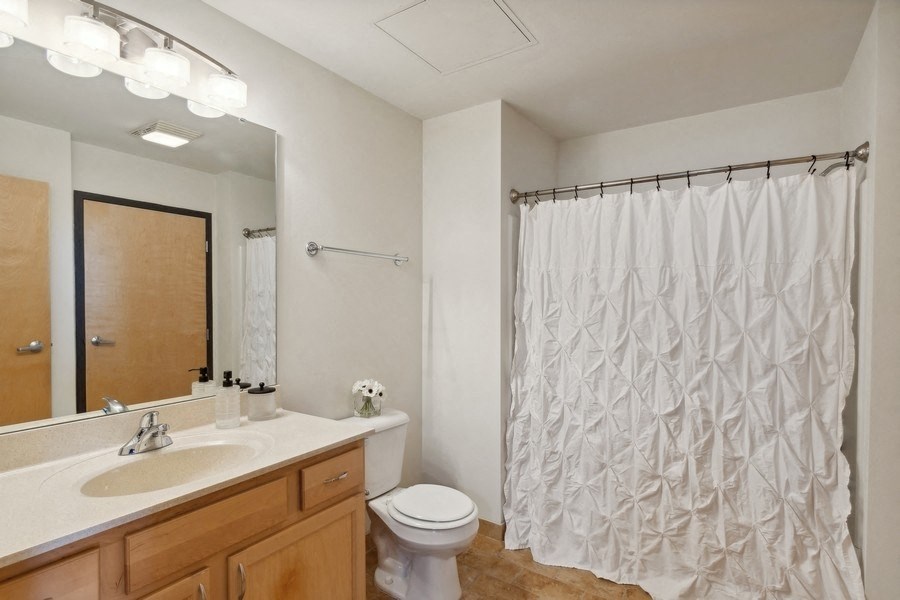 a bathroom with a shower curtain and a sink and a toilet