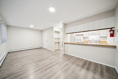 A room with a white wall and a wooden floor.