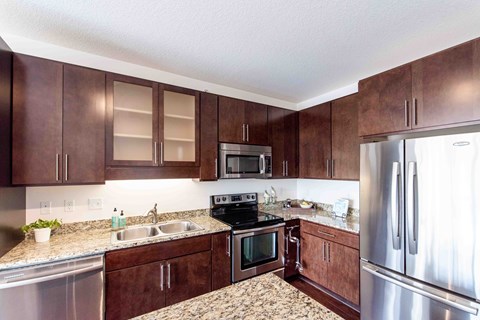 A kitchen with brown cabinets and stainless steel appliances.