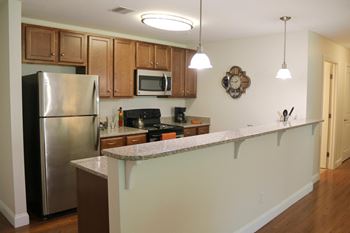 a kitchen with a long counter and a stainless steel refrigerator at Mallory Ridge, Bloomfield, 06002