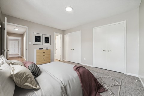 A bedroom with a bed, a dresser, and a wardrobe.