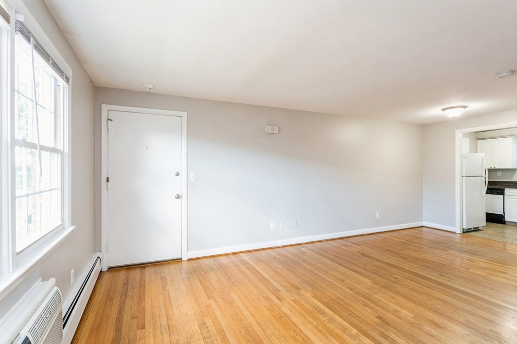 a living room with a wood floor and a white wall with geometric patterns on it