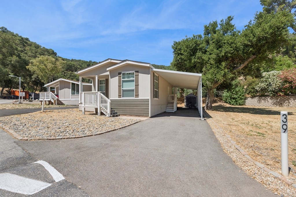 A house numbered 309 is surrounded by a gravel area and a paved path.