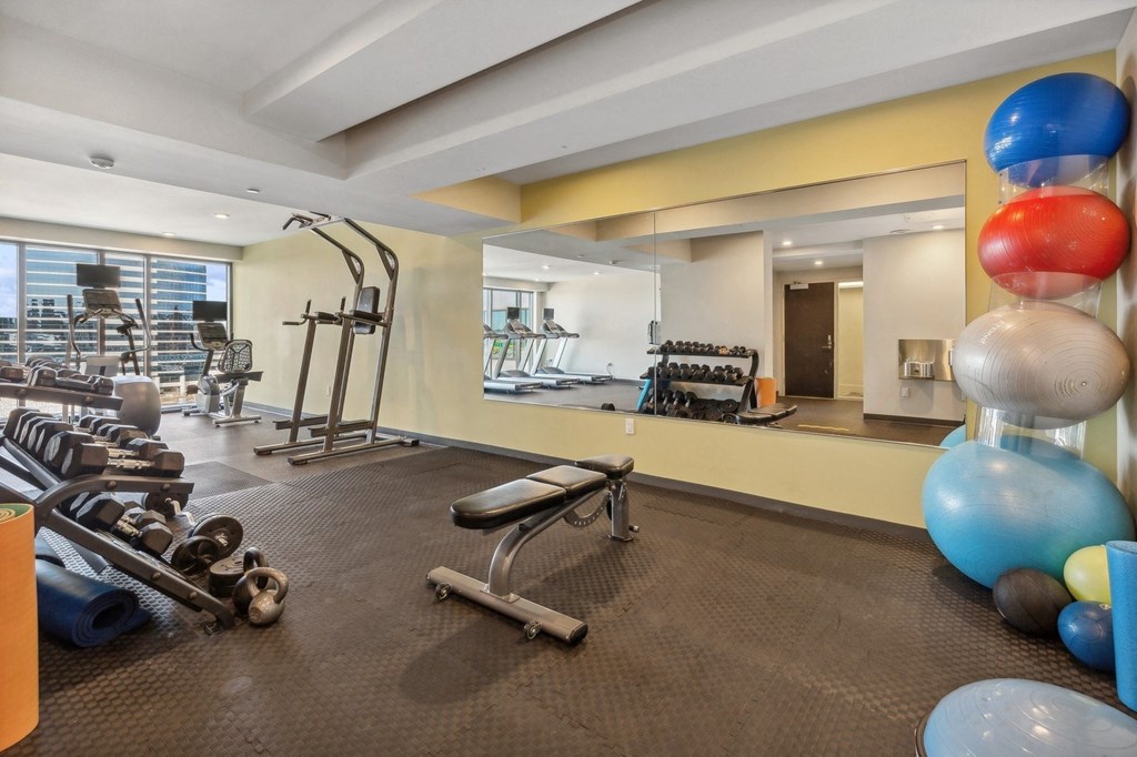 a gym with weights and balloons on the floor and a large mirror at The Rowe, Grand Rapids, Michigan
