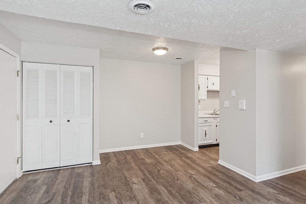 A room with a white door and wooden flooring.
