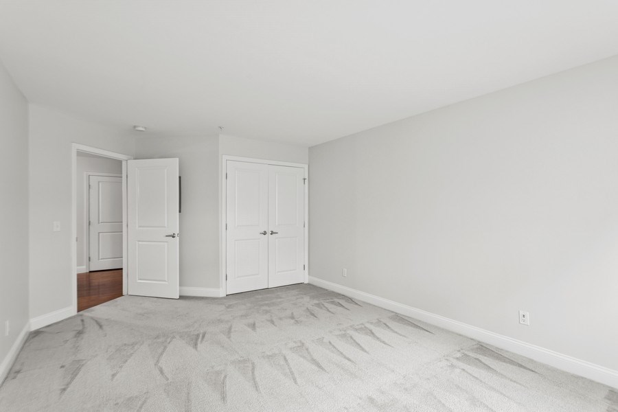 A room with two white doors and a carpeted floor.