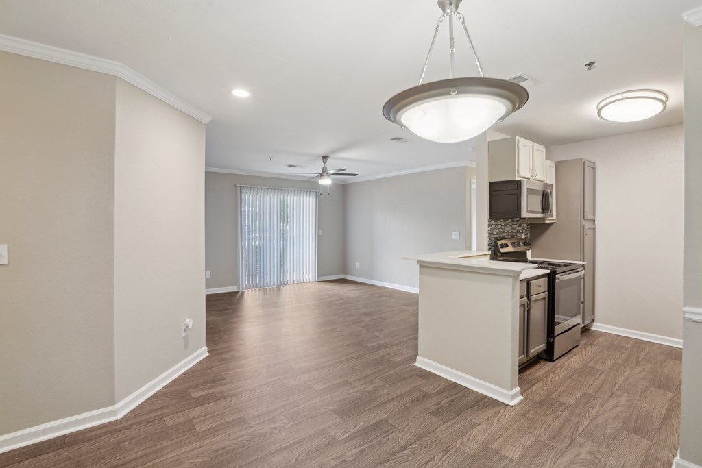 A kitchen area with a microwave, oven, and a refrigerator.