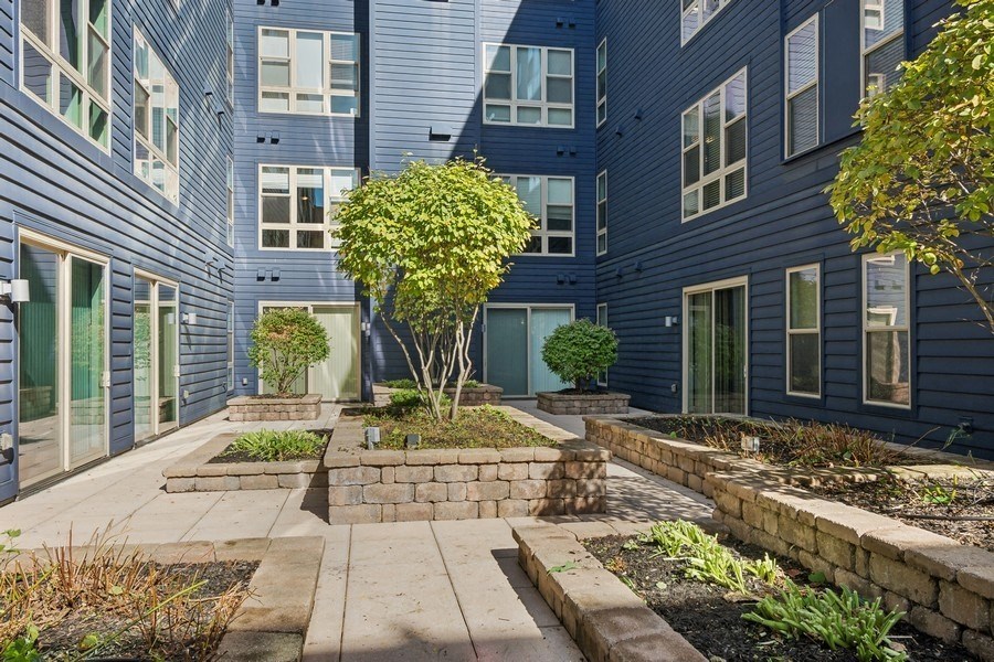 the courtyard of a blue building with a tree in the middle