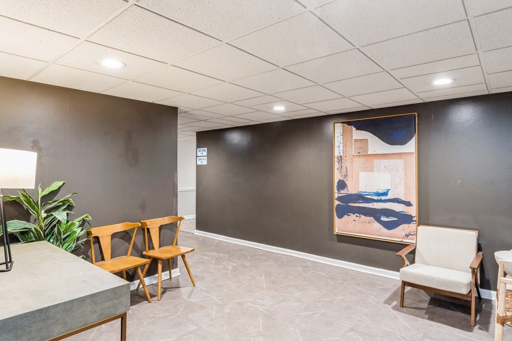 A room with a grey floor and a painting on the wall.