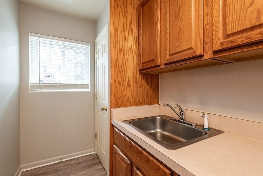A kitchen with wooden cabinets and a white sink.