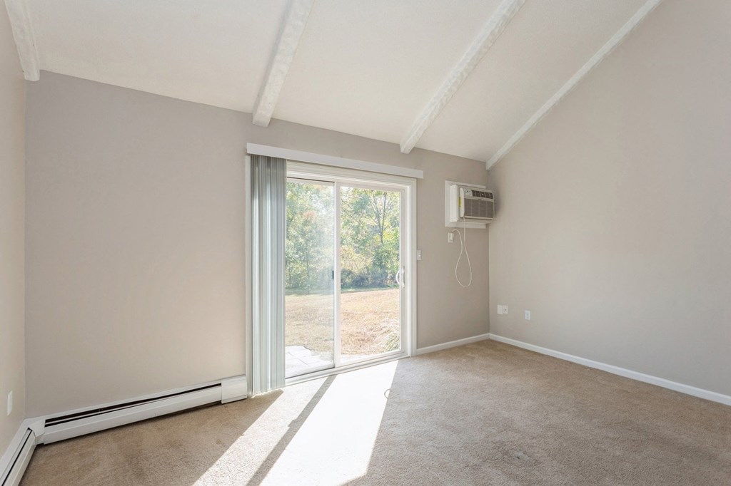 a curved room with a window and white walls wiht sliding doors