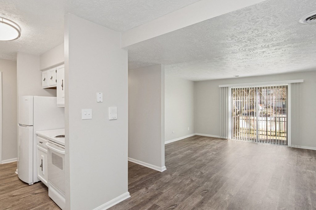 A white kitchen with a refrigerator, oven, and sink.