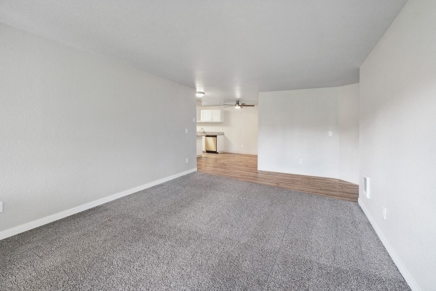 the living room and dining room of a house with white walls and carpet at Sundial Apartments, Wilsonvile, Oregon