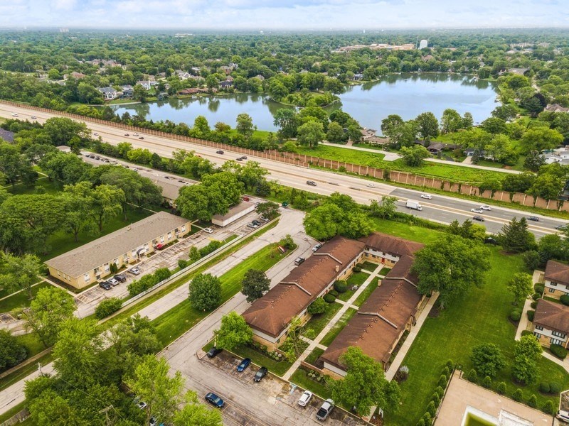 an aerial view of a factory and a road and a body of water