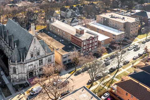 A large building with a tower is surrounded by other buildings at Pleasant Oak Apartments, Oak Park, Illinois