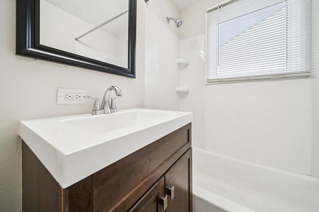 A white sink is on a brown vanity.