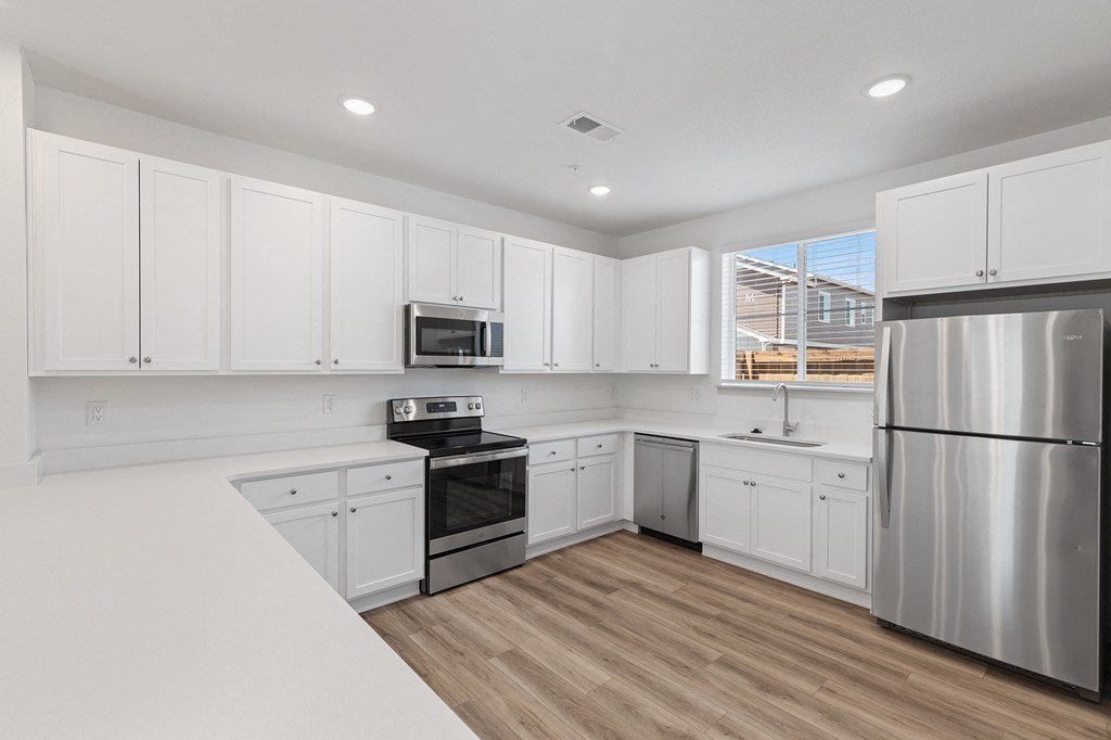 a renovated kitchen with white cabinets and stainless steel appliances