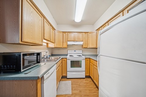 A kitchen with wooden cabinets and white appliances.