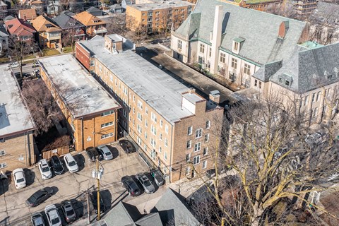 A parking lot with cars and a building in the background at Pleasant Oak Apartments, Oak Park, IL, 60302