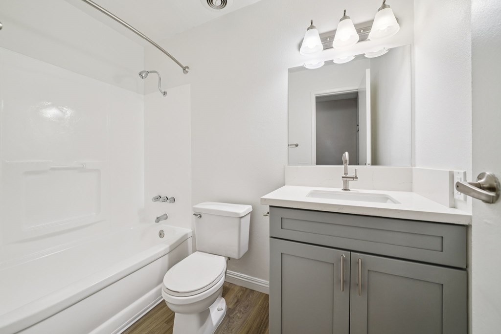 A white toilet sits next to a white sink in a bathroom.