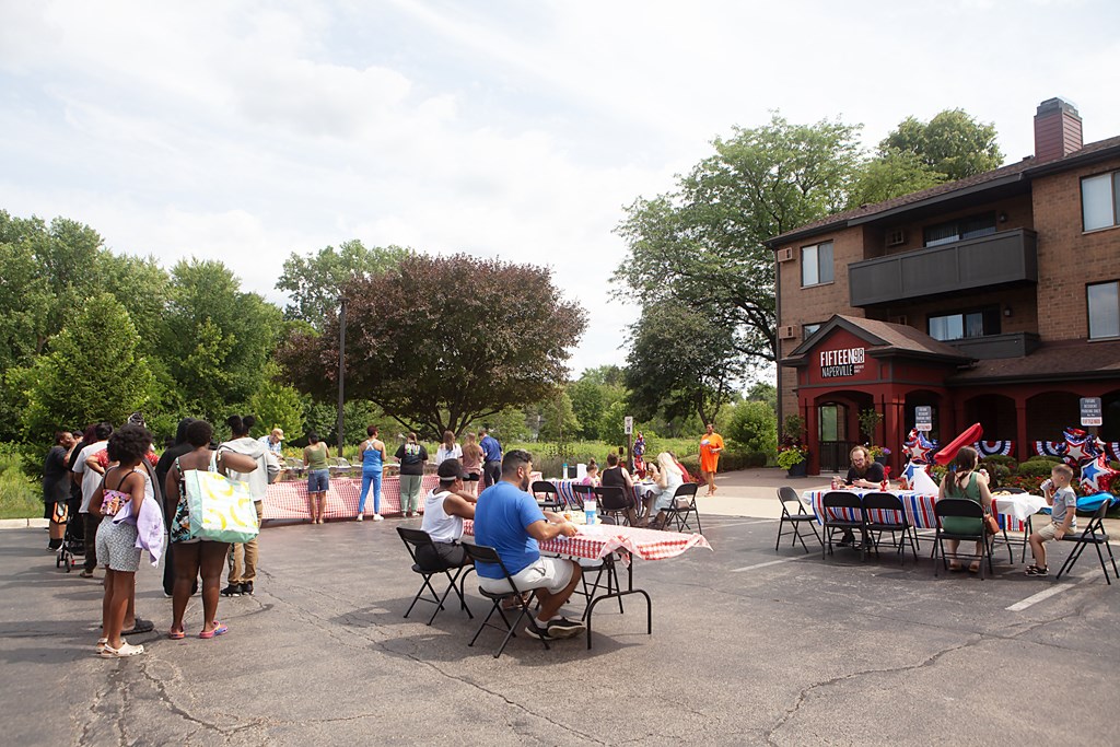 a large group of people sitting at tables outside of a building