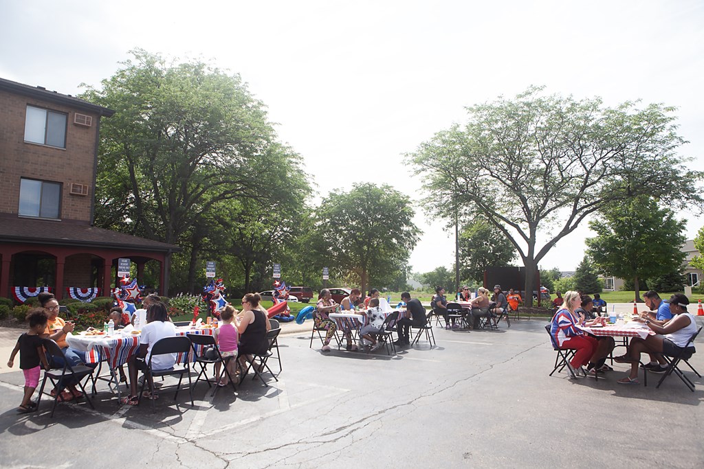 a large group of people sitting at tables in a parking lot