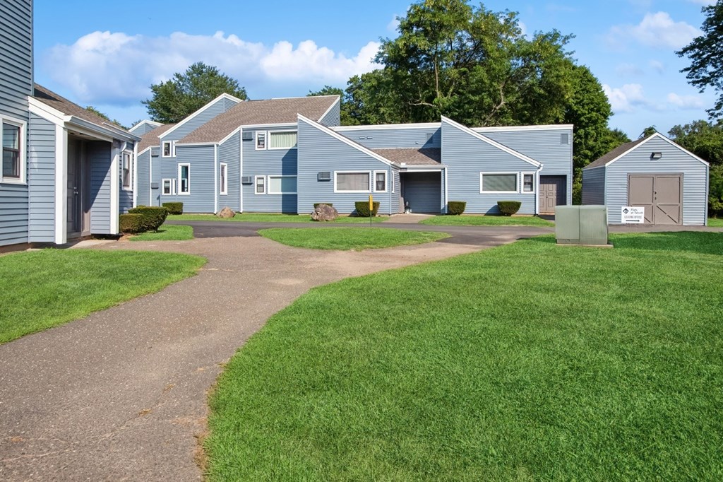 An apartment building with a grassy area in front.