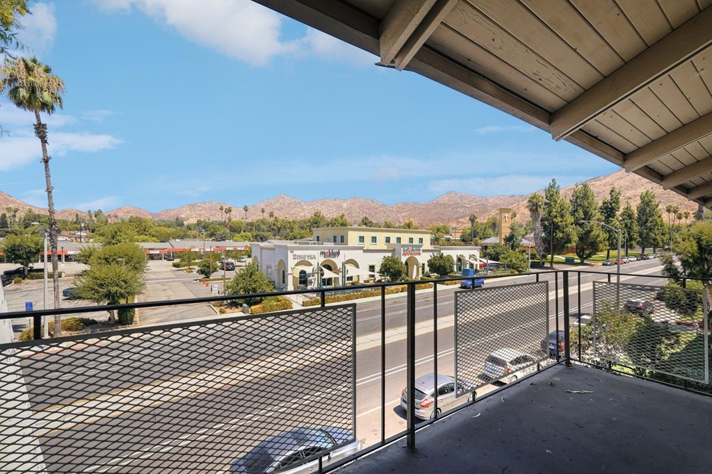 the view of the parking lot from the balcony of a building with a parking lot