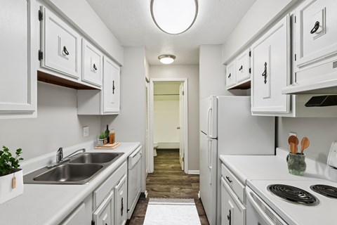A kitchen with white cabinets and appliances.
