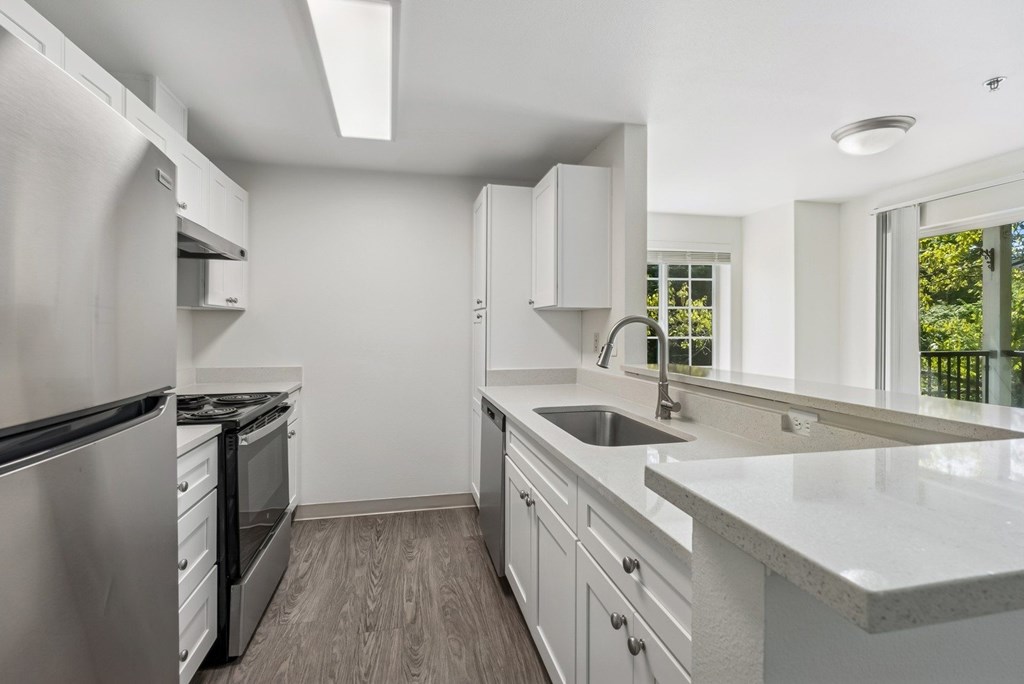 A modern kitchen with stainless steel appliances and white cabinets.