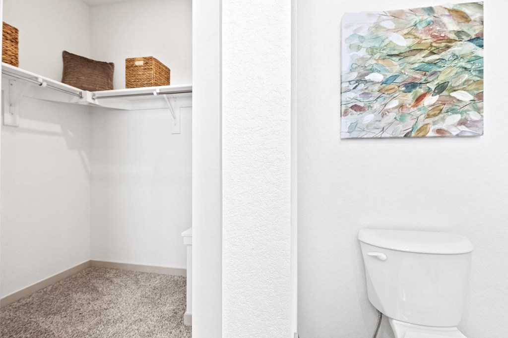 a white bathroom with a toilet and a shelf above it