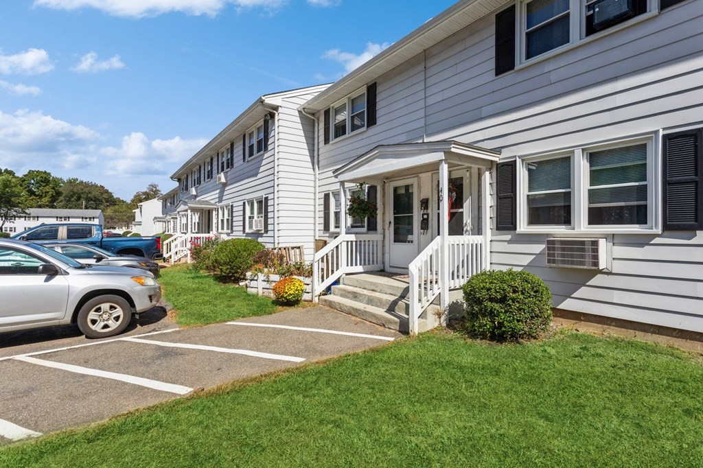 white apartment buildings with cars parked in front of it at Fox Hill Commons, Vernon, 06066