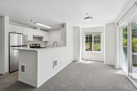 A kitchen with white cabinets and a stainless steel refrigerator.