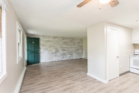 an empty kitchen and living room with a green door