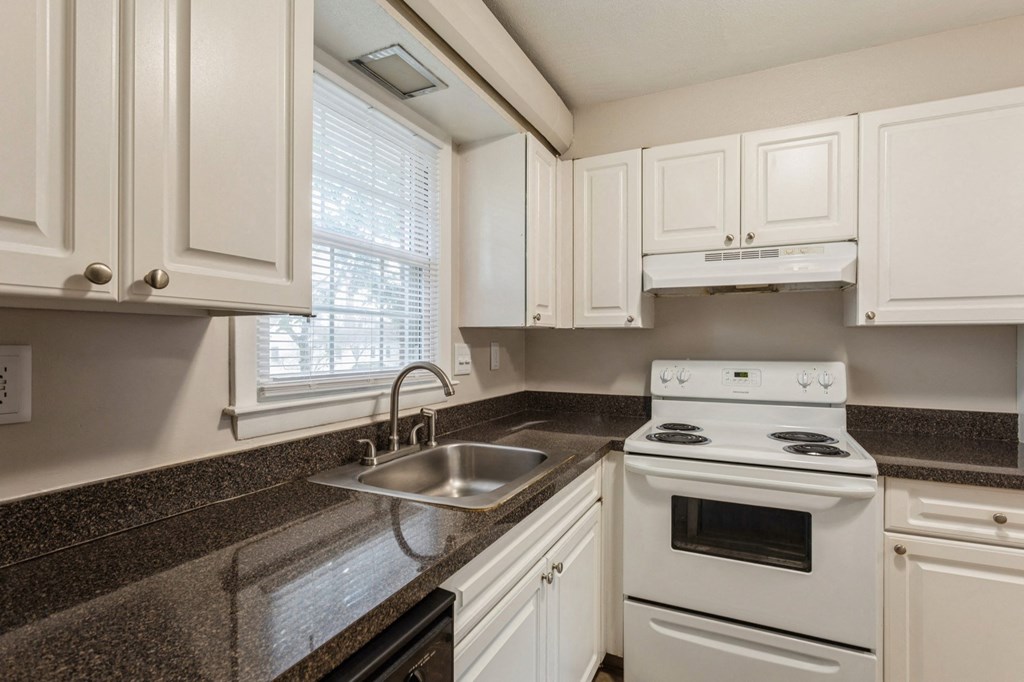 a kitchen with white appliances and granite counter tops