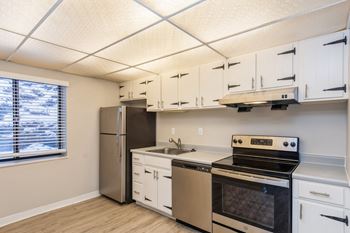 A kitchen with white cabinets and stainless steel appliances.