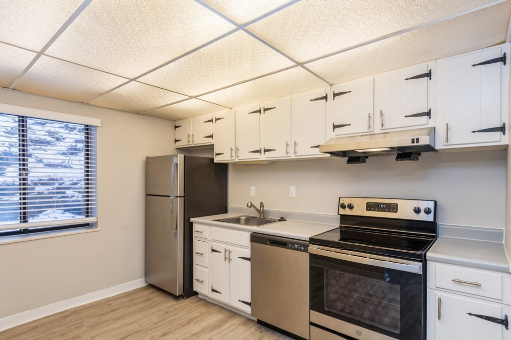 A kitchen with white cabinets and stainless steel appliances.